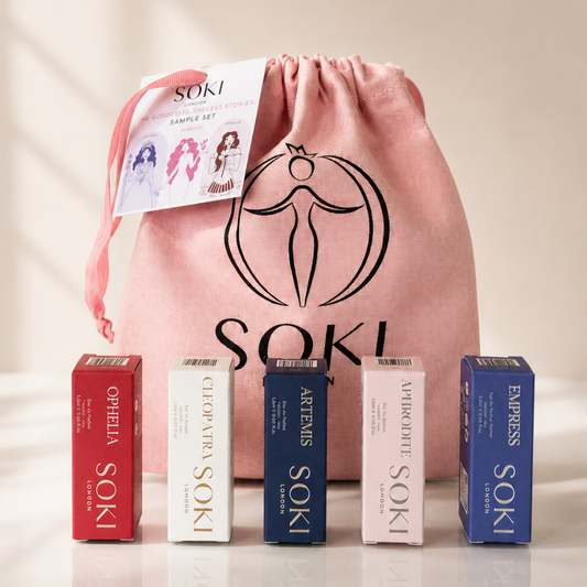 SOKI hair sample set with a pink drawstring bag, a sample card, and five boxed fragrance sa,ples in red, white, navy, pale pink, and blue arranged in front on a light beige background.