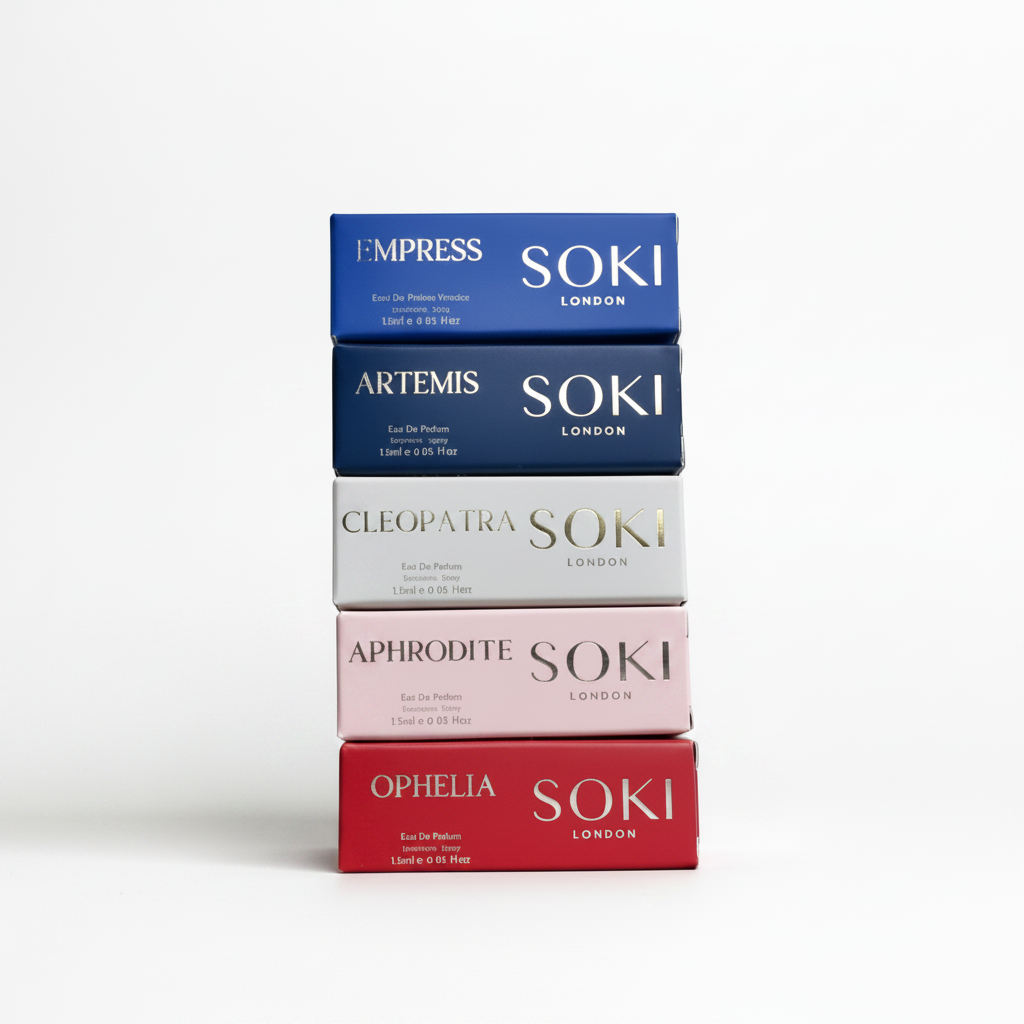 A stack of five Soki London perfume boxes in different colors: blue, navy, white, pale pink, and red, arranged vertically on a light gray background.
